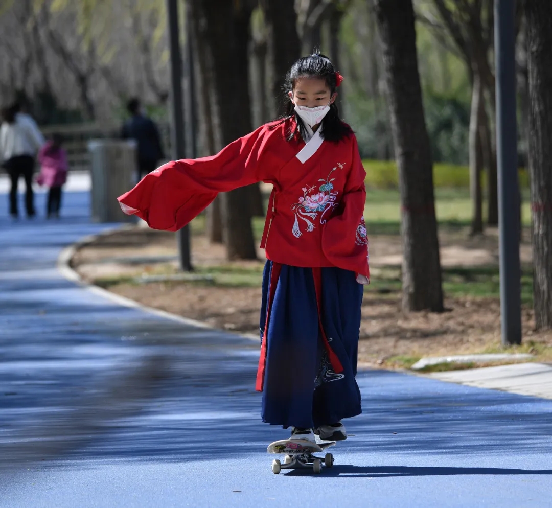 一位穿汉服的女孩在北龙湖湿地公园练习滑板 丁友明摄影