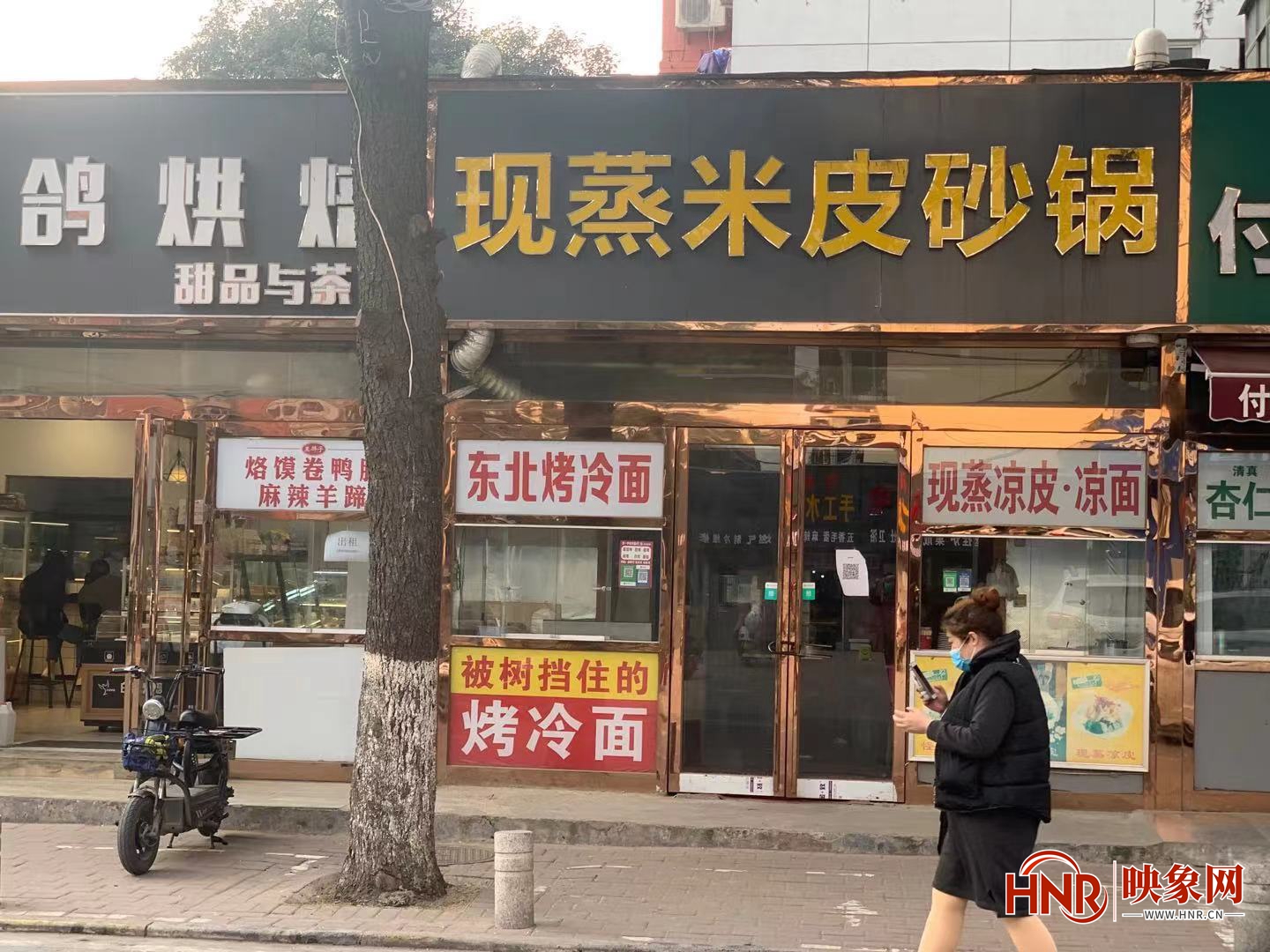 郑州一小吃摊被树挡住 店主干脆起名“被树挡住的烤冷面”