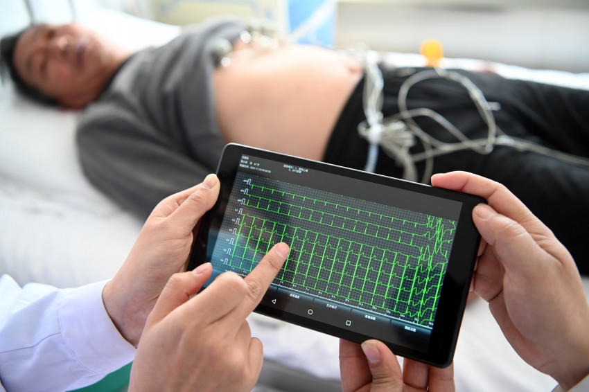 医马俊平(左二),携带移动式远程心电图采集仪来到村民家中,在沁阳市